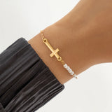 Golden bracelet with cross and pearls
