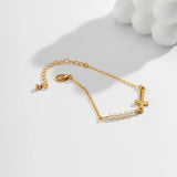 Golden bracelet with cross and pearls