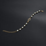 Armband mit Perlen aus Muschel und Kreuzanhänger